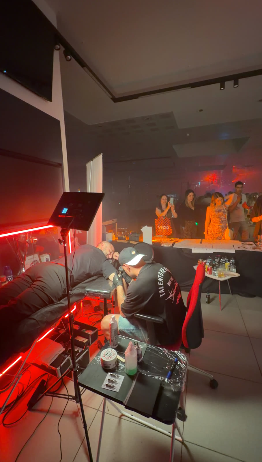 Tatuaje en directo con luz roja en un evento de empresa
